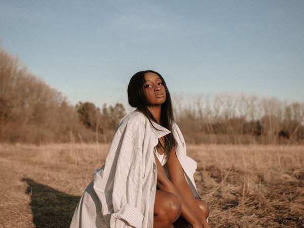 Serene woman meditating in a calm, minimalist environment.